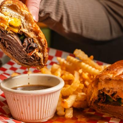 Beef sandwich being dipped in beef broth.