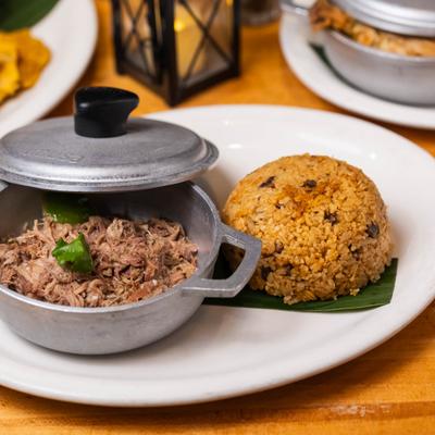 A small pot of slow-cooked pork shoulder served with rice.