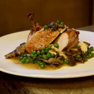 Roasted duck with peas and mushrooms.