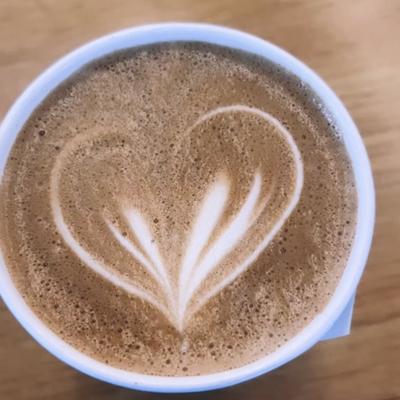 Latte with a heart-shaped foam art design, top view.