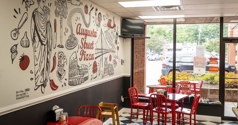 Interior of cozy pizzeria dining area with red tables and chairs
