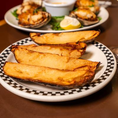Potato skins served on the table alongside a plate of stuffed scallops.