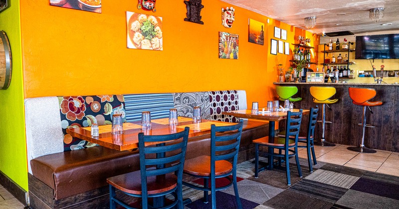 Interior, tables and chairs with glasses with bar in the back