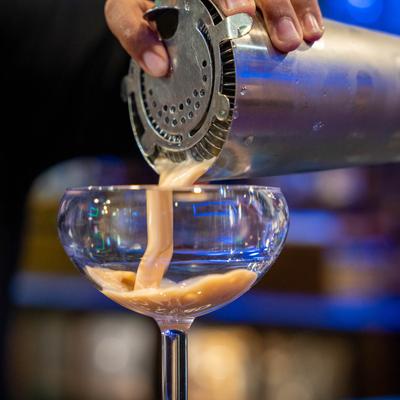 Bartender pouring a cocktail.