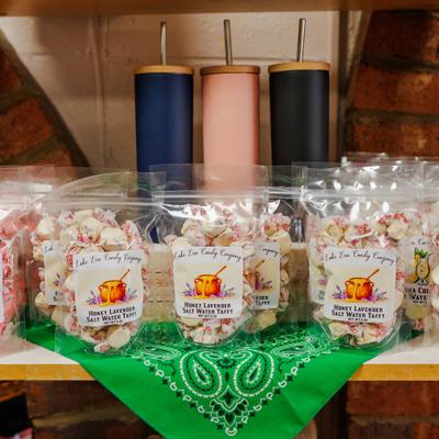 Bags of honey lavender taffy displayed with metal tumblers.
