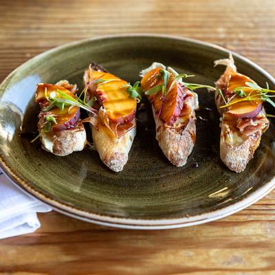 Crostini with brie, sliced prosciutto and fig gastrique.