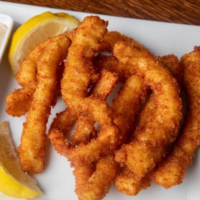 Fried calamari strips served with lemon wedges.