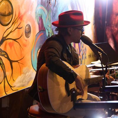 A musician playing the guitar and singing.