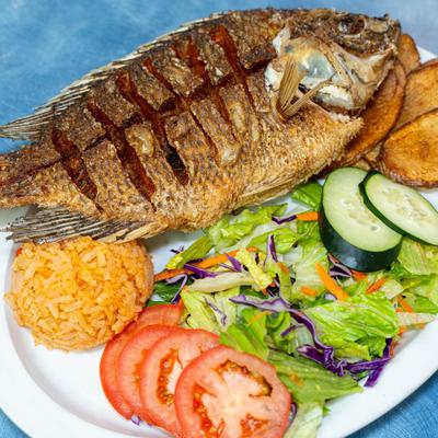 Whole fried fish served with seasoned rice and salad.