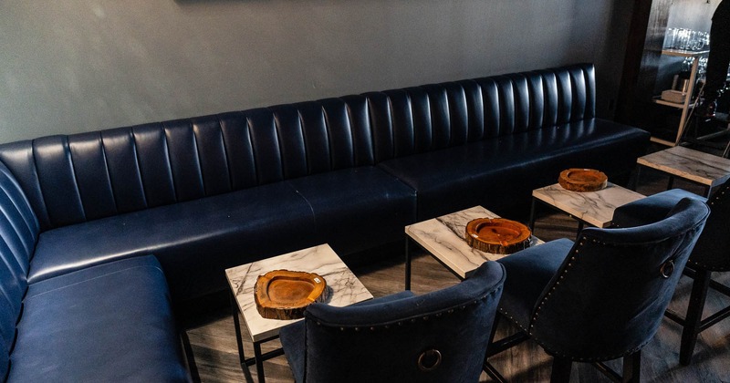 Interior, dark blue seating area with tables