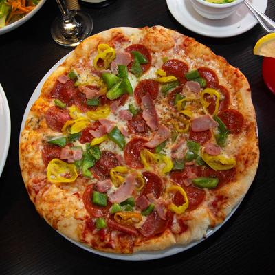 Pizza with tomato sauce, anchovies, olives, sausage, mushrooms, pepperoni,  peppers, and onion.