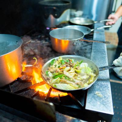 Chef frying food in a pan.