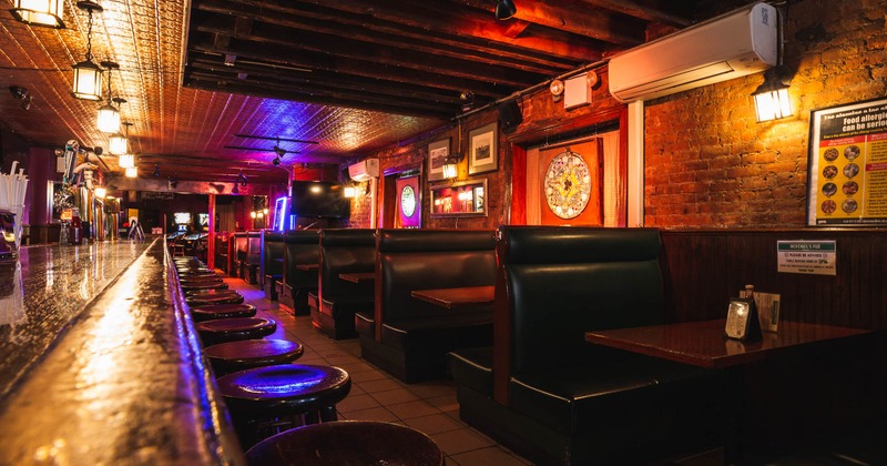 Bar stools on the left, booths and tables on the right