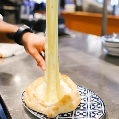 In the kitchen, the cheese is spread over the plate by hand