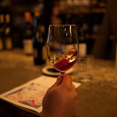 Customer swirling red wine in a glass.