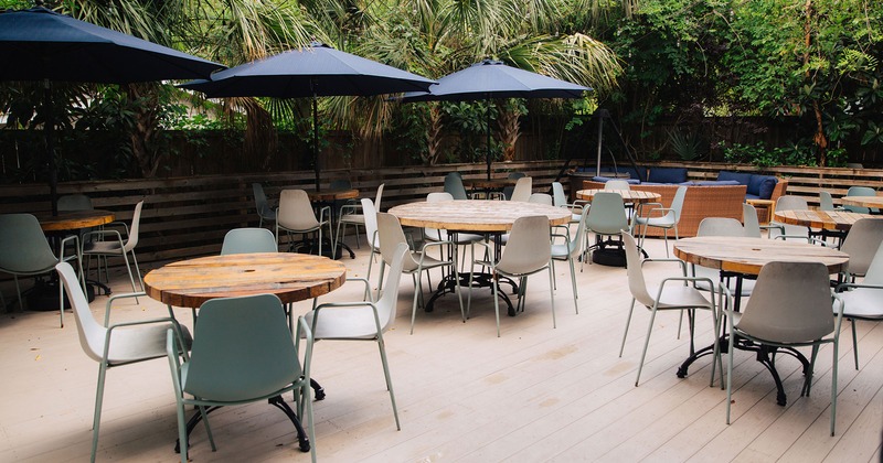 Patio, seating area with round tables, chairs and sunshade umbrellas