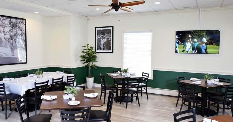 Interior, dining area, tables with chairs ready for guests, ceiling fan, framed pictures