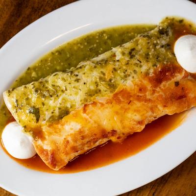 Chimichangas, smothered in green and red sauces.