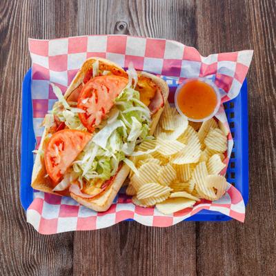 Hot Deli Sub with a side of chips and a dressing.