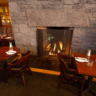 two tables beside fireplace with a fire going
