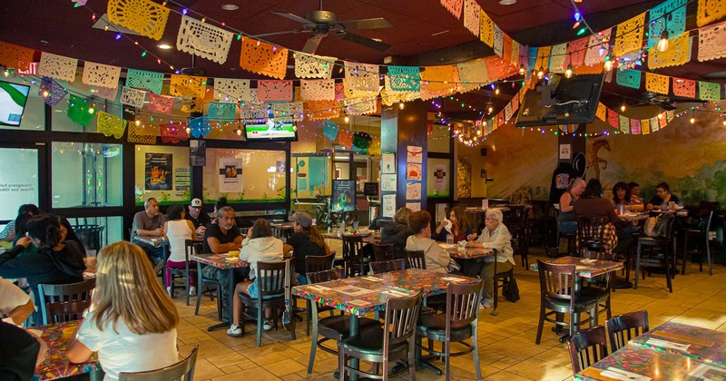 Interior space, dining area full of guests chatting and enjoying their food and drinks