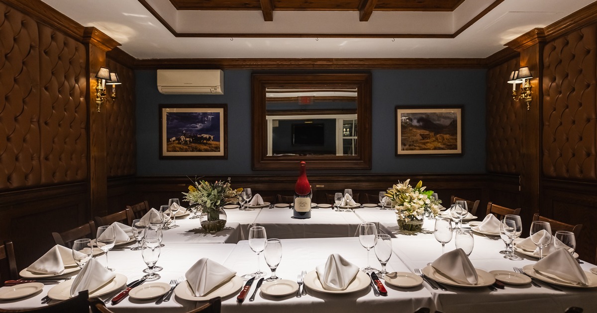 Elegant private dining room with set tables arranged in a square shape