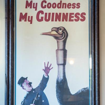 Vintage beer advertising poster framed on the wall.