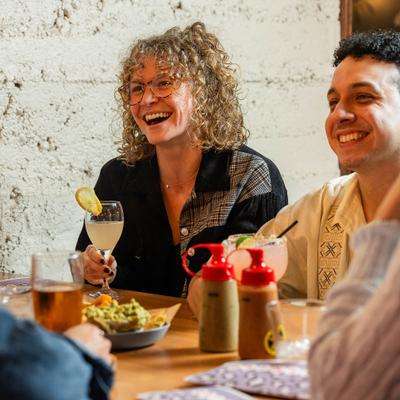 People enjoying food and drinks in a rustic-themed restaurant.