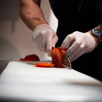 A person slicing tomatoes.