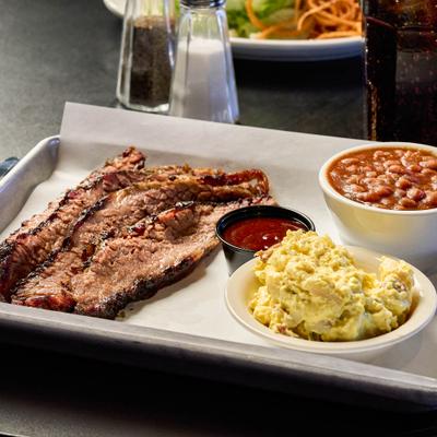 Brisket Plate with sides of potato salad, beans and a dipping sauce.