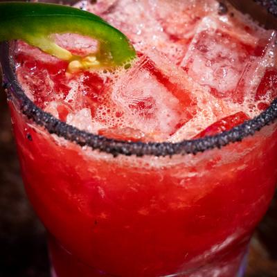 Spicy blood orange drink, garnished with a jalapeno slice.