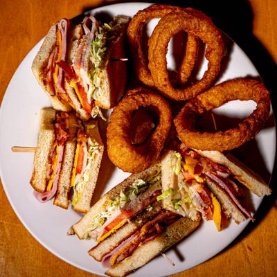 Club sandwiches served with onion rings.