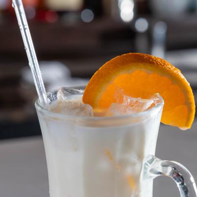 Pina Colada garnished with a slice of fresh orange, close-up.