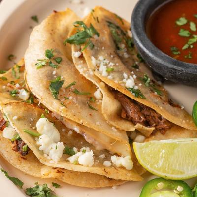 Birria Tacos served with sauce