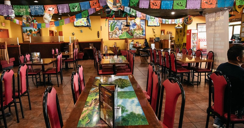 Interior, dining tables, room decorated with paintings and street banners