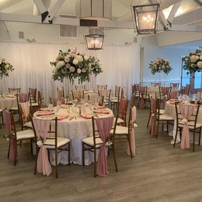 Pink accented tables beneath floral arrangements.