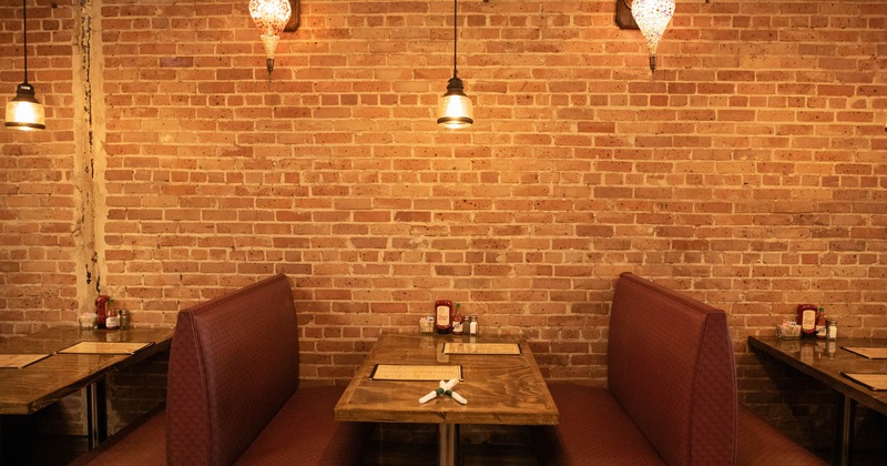 Dining area, booths with tables, brick wall in the back