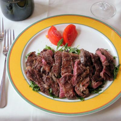 Grilled sliced beef served over arugula.
