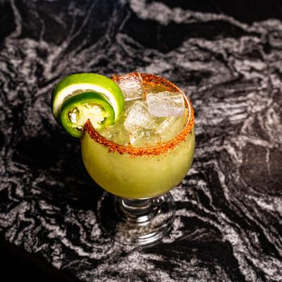 Spicy Margarita garnished with a chili rim and slices of lime and jalapeno.