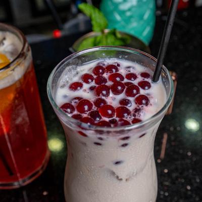 Boba Milk Tea featuring bursting boba pearls, close-up.
