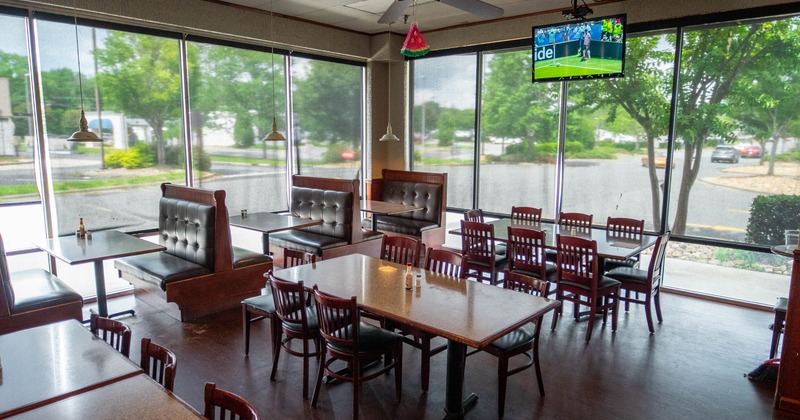 Interior,  large windows with blinds, wooden tables with wooden chairs, leather booths