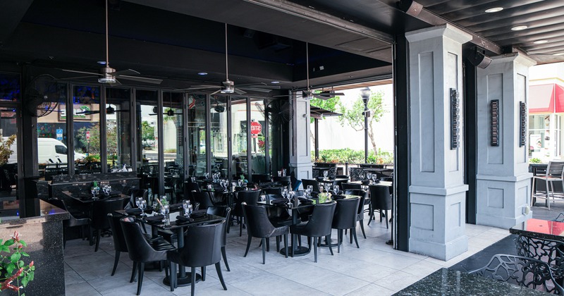 Covered outdoor dining area with set tables