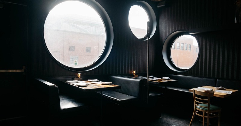 Interior,booths with tableware, light coming from round shaped windows