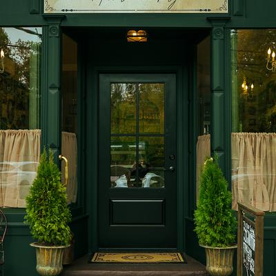 Exterior, entrance with a sign and potted plants.