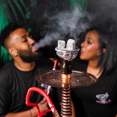 Two people smoking hookah at the table.