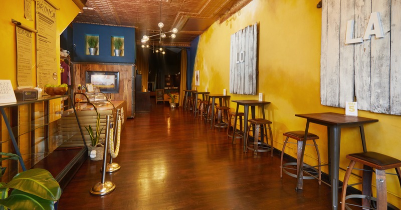 Interior, front desk, table and bar stools by a wall