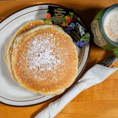 Pancakes with powdered sugar and fruit spreads.