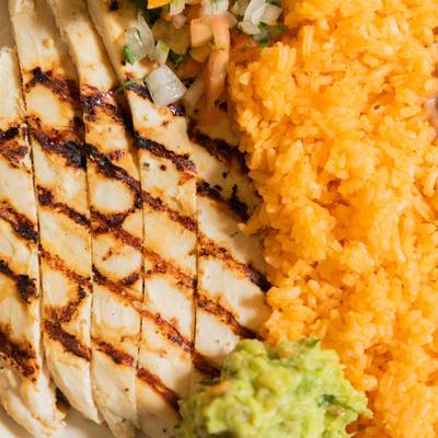 Grilled chicken, served with guacamole, rice, and beans.