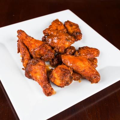 Jumbo party wings on square white plate.
