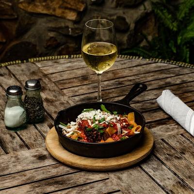 Braised Short ribs served on a table with a glass of white wine